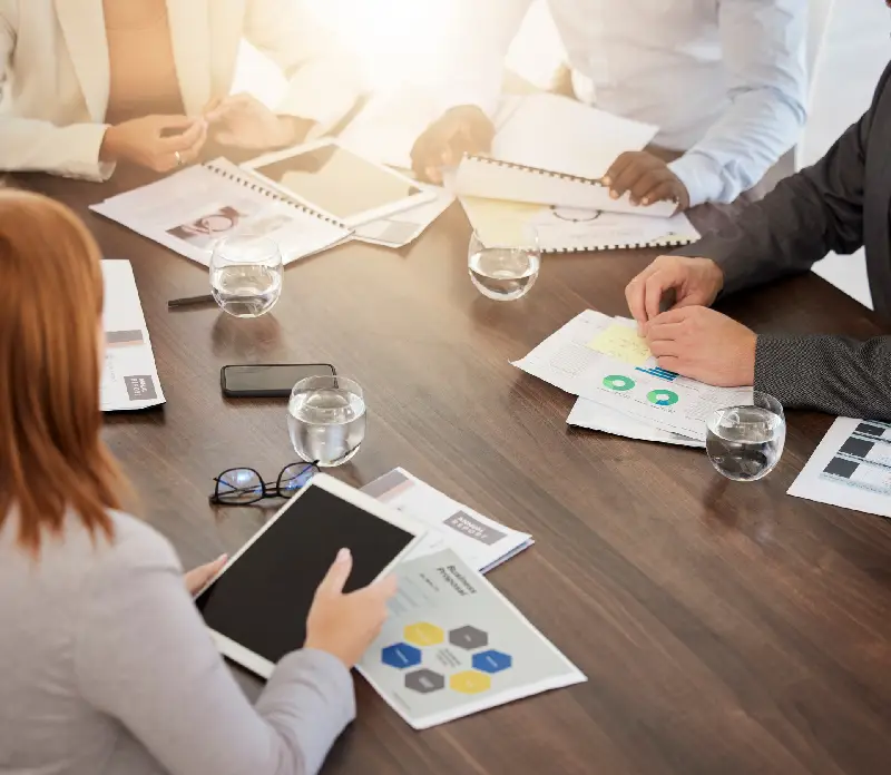 A diverse group of professionals collaborates around a conference table A diverse group of professionals collaborates around a conference table